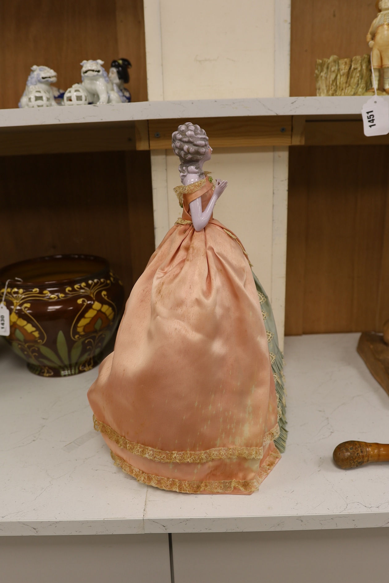 A 1920’s German porcelain 'pin dolly' with tea cosy dress, 46cm high. Condition - good some marks to the silk of cosy/dress